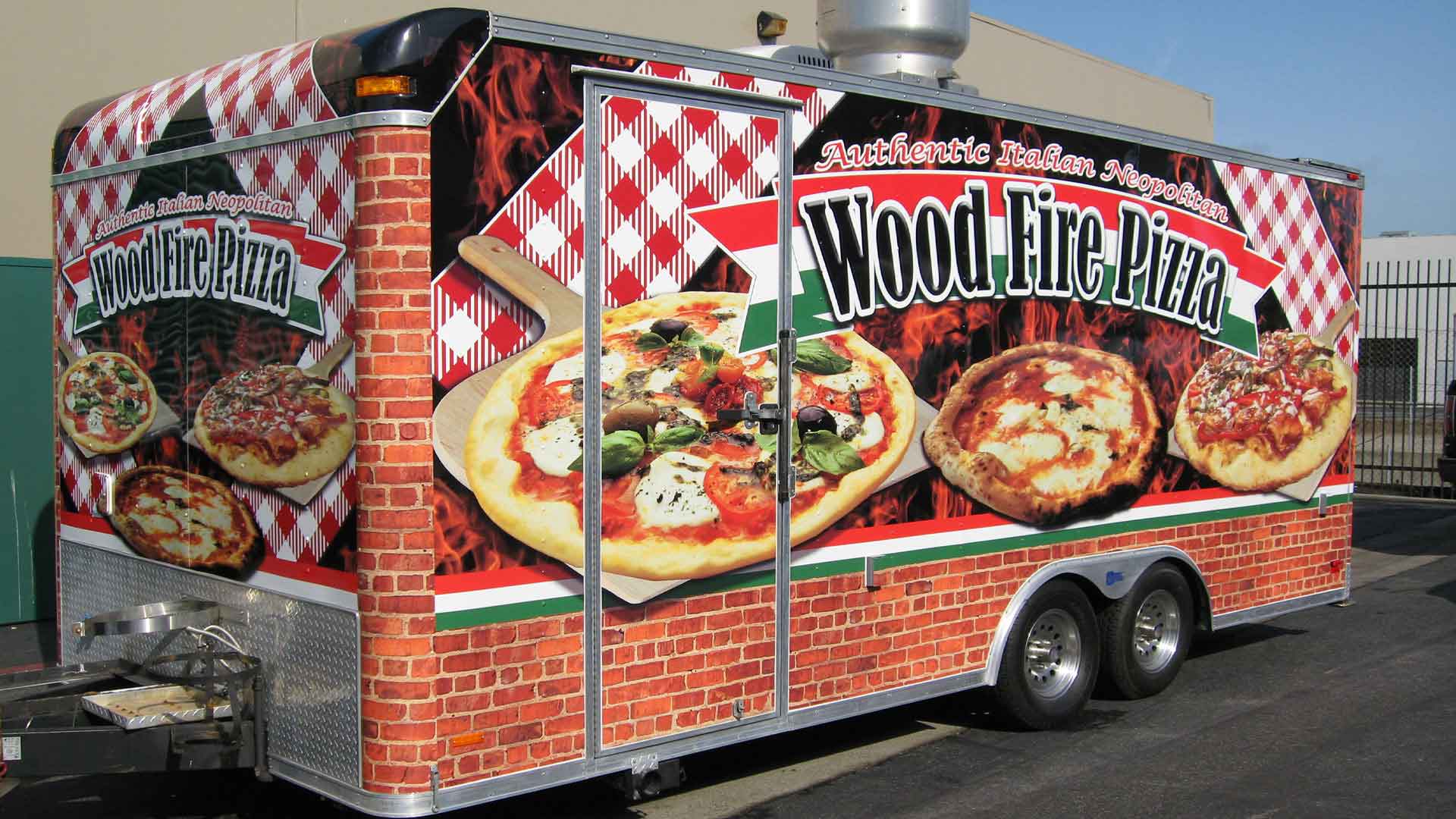 Colorful 20 foot trailer wrap designed and installed for Wood Fire Pizza with large images of pizzas with italian themed background imagery