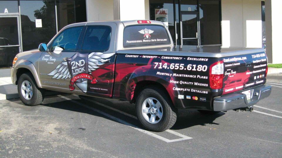 Red, white and black partial wrap on ford ranger with winged logo for detailing company