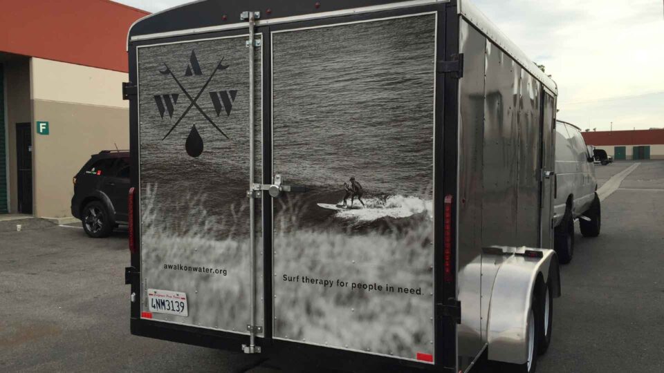 Enclosed trailer wrap with surfing imagery on the rear