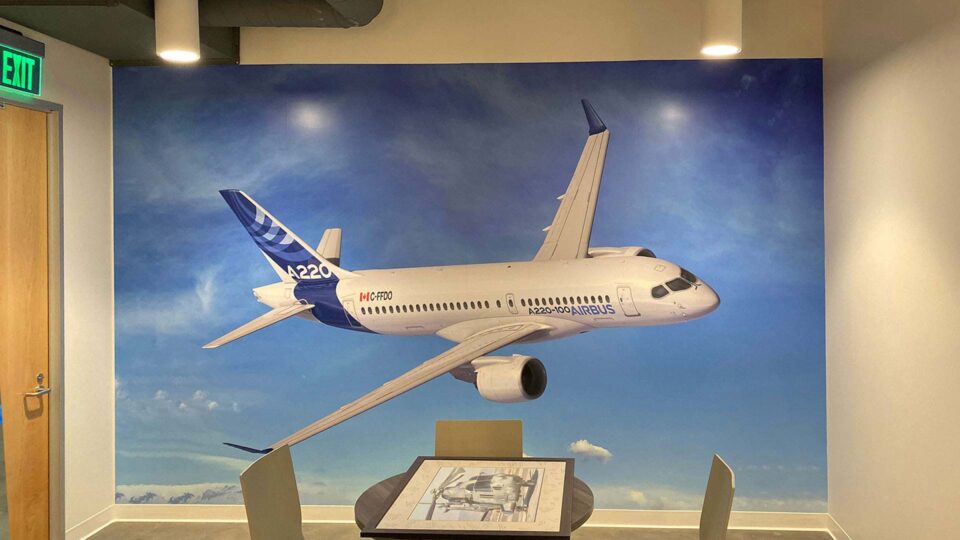 Wall graphic of white airplane flying in sky