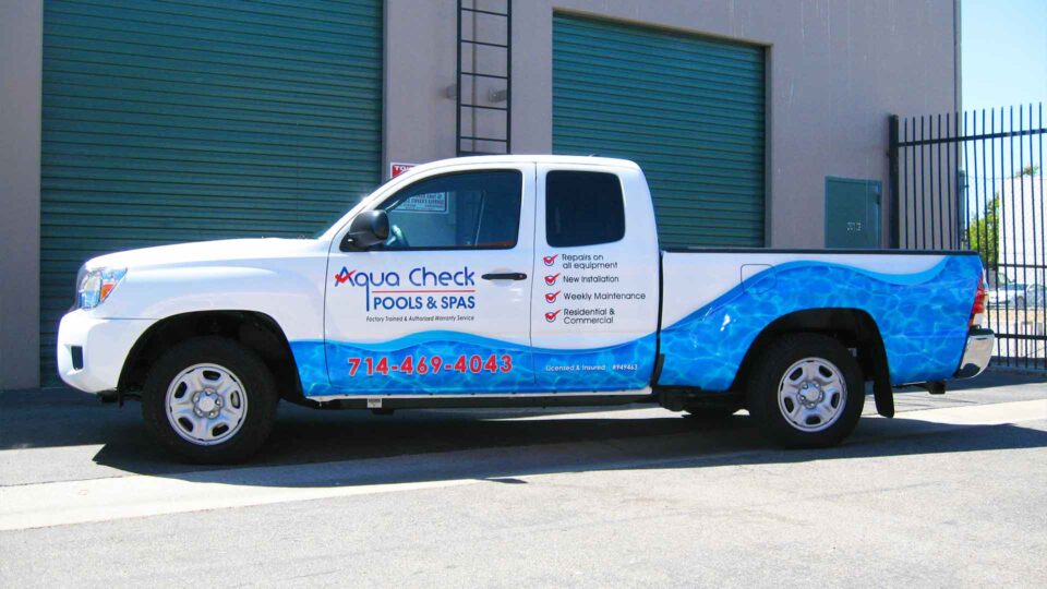 partial Ford truck wrap with water on lower half and contact info for Aquacheck pools