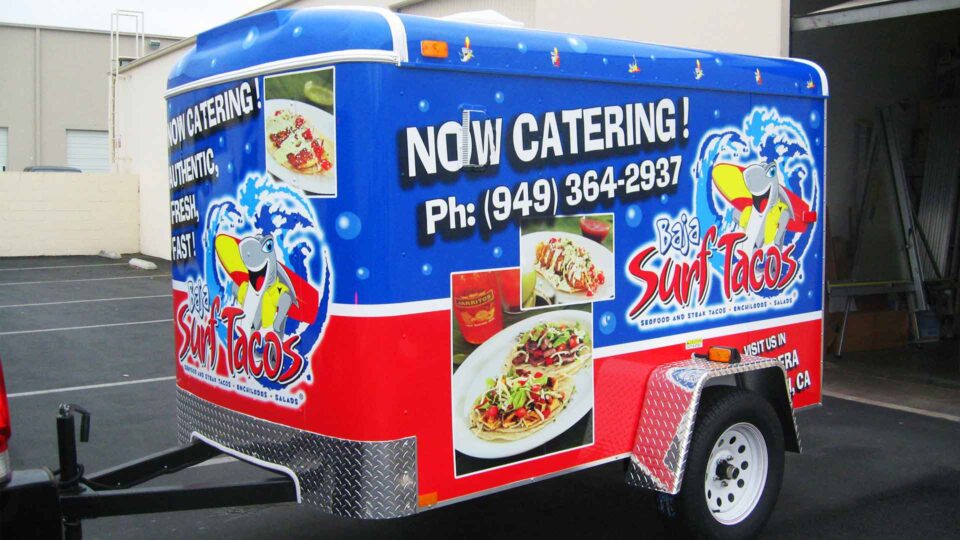 Red and blue trailer wrap featuring plates of fish tacos and catering services for Baja Surf Tacos