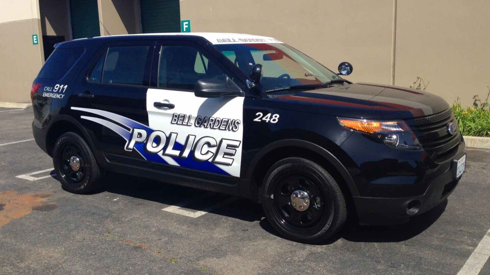 Black and white Ford Explorer partial wrap with Bell Gardens police logo