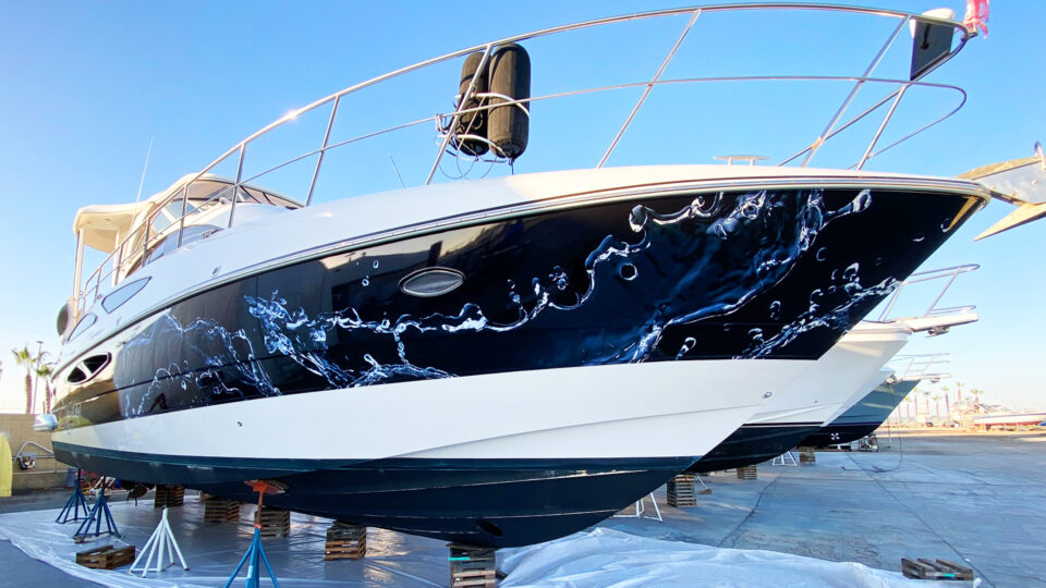 White boat on blocks with blue water vinyl boat wrap