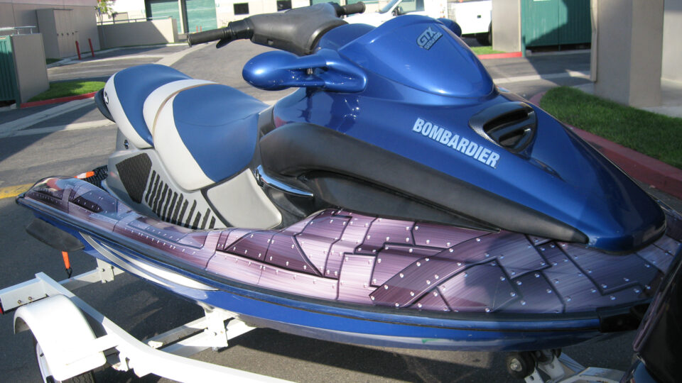 metall plate looking gray vinyl Seadoo Bombadier wrap. Sitting on trailer in parking lot