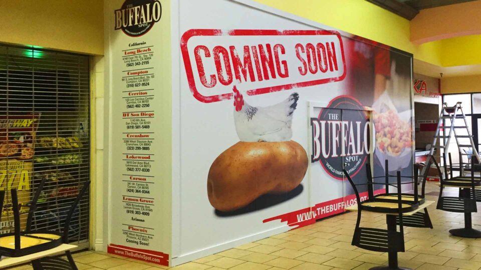 Coming soon barricade wrap featuring a chicken, potato, food and Buffalo Spot logo