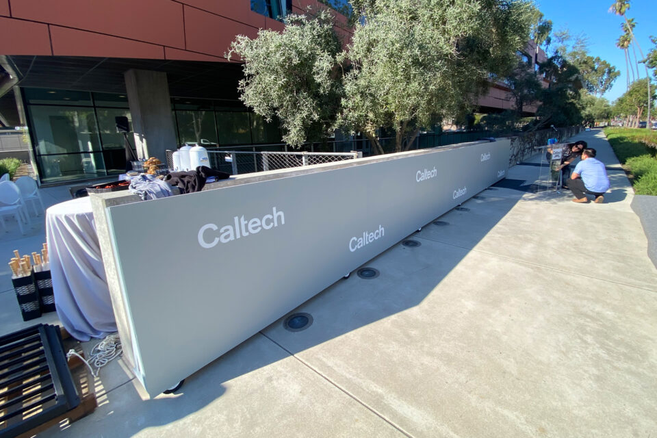 Gray rectangular rolling sign with Caltech in white text