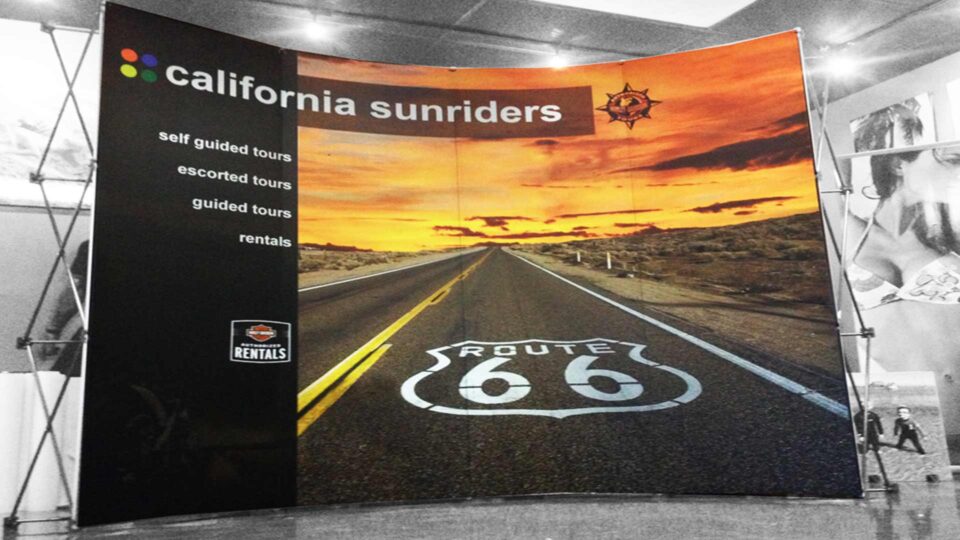 Portable trade show banner for California Sunriders featuring Route 66 highway through the desert with orange and yellow sunset