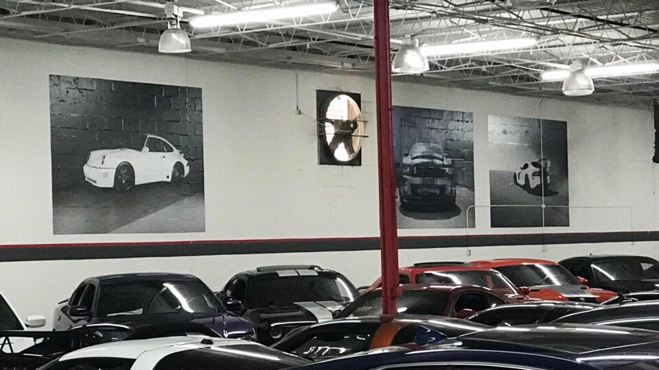 Black and white wall decals of cars at auto dealer