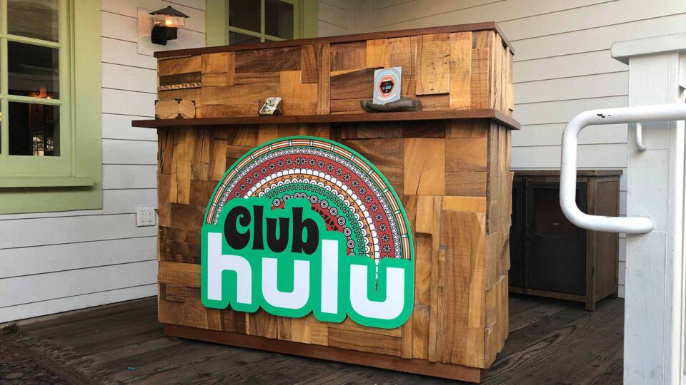 Green Club Hulu gatorprint sign on wood special event display