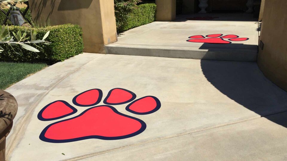 Die Cut floor decals of Red and black dog paws on cement entry way