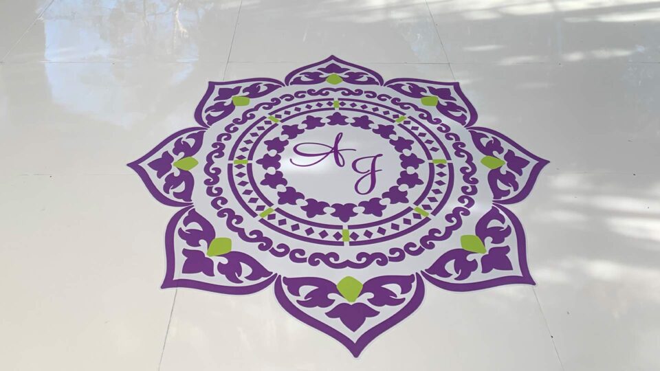 Purple and green flower die cut dance floor decal with intials AJ in the center on white floor