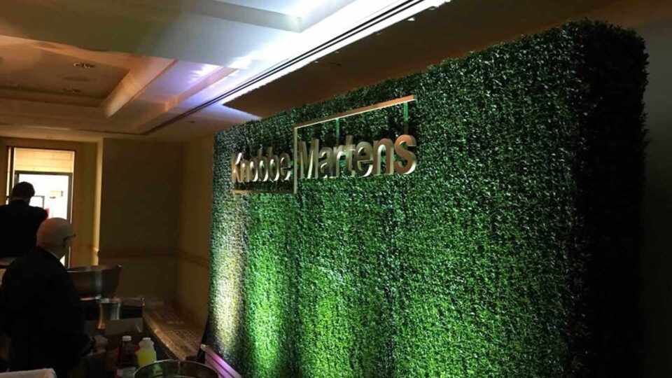 Gold Knobbe Martens router cut sign on greenery photo background for special event