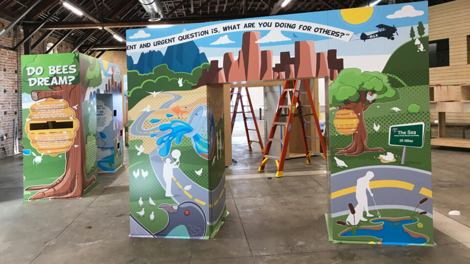 Colorful Kids Archway wraps with mountains, trees and blue sky in warehouse