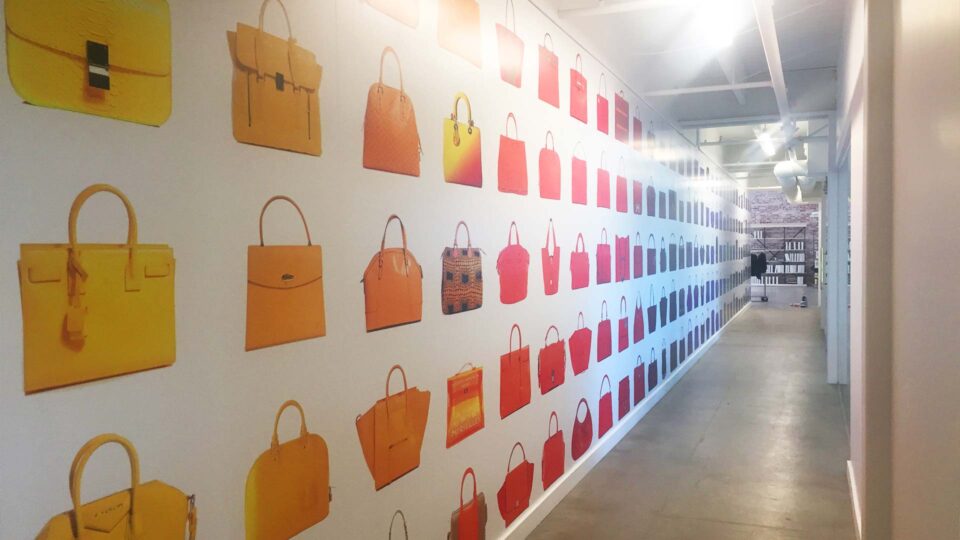 White wall graphic with colorful luxury purse images for Fashionfile corporate office.
