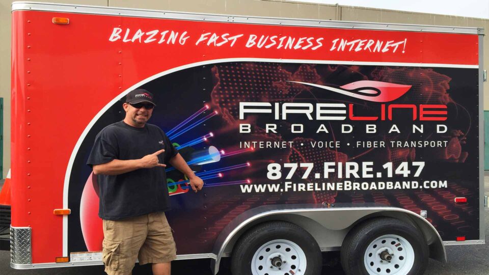 full trailer wrap with red background featuring Fireline Broadband service