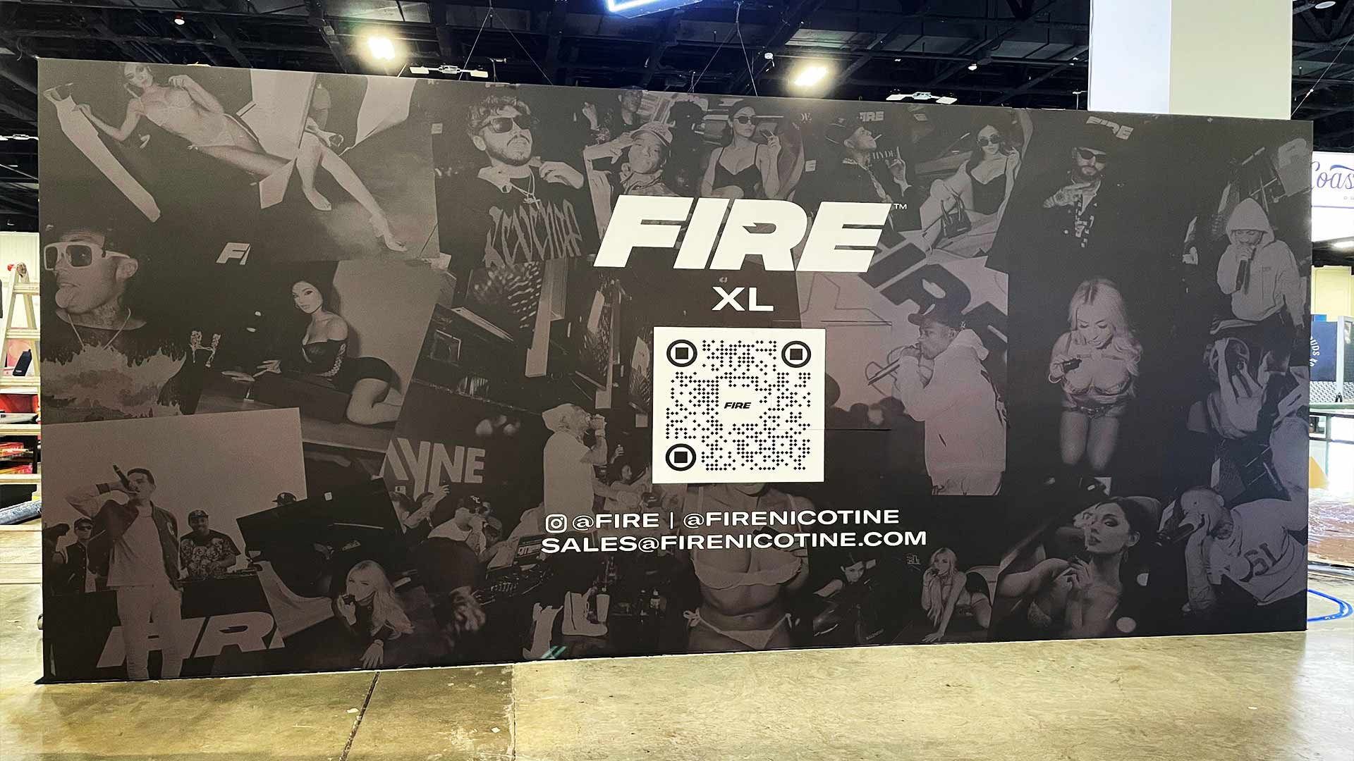 Black and white trade show wall graphics with images of celebrities and white FIRE Logo and barcode