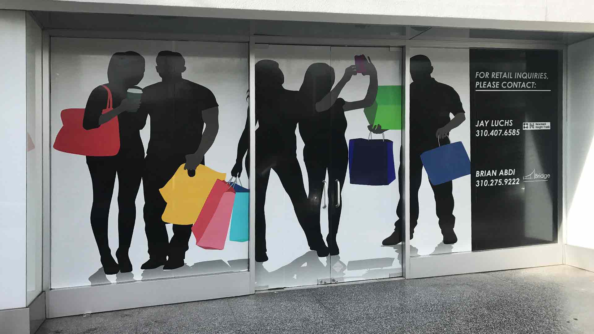 Solid vinyl window graphics for space for lease showing people shopping with bright bags