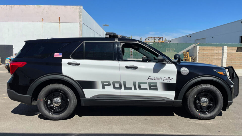 Black and white Ford Explorer partial wrap with Fountain Valley police logo