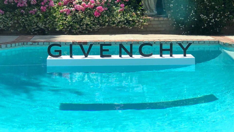 Router cut black Givenchy sign floating in pool for sales event