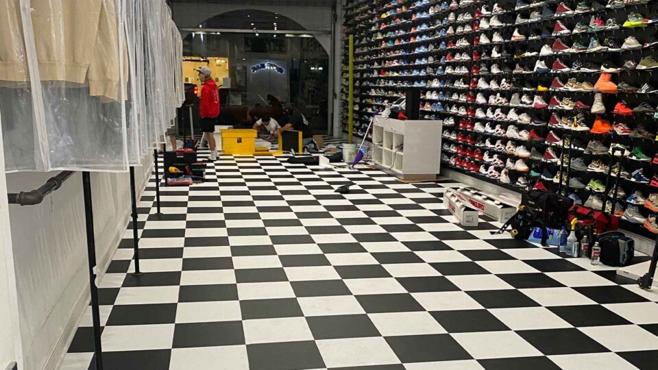 black and white checkered floor graphic in shoe store with wall of colorful shoes