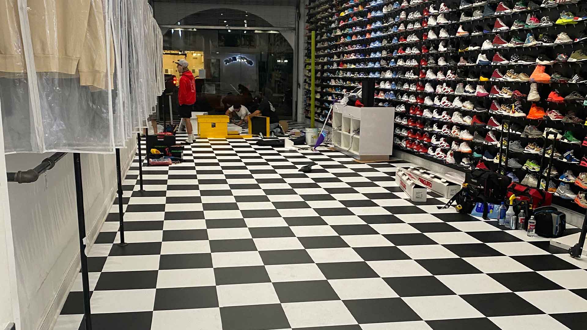 black and white checkered floor graphic in shoe store with wall of colorful shoes