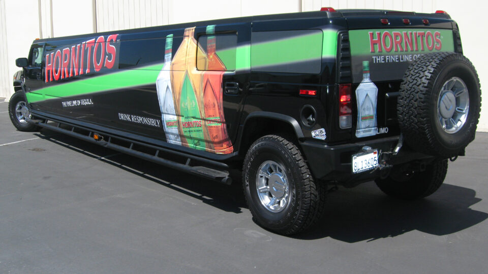 Black Hummer Limosine vehicle wrap with red Hornitos logo, green diagonal stripe and bottles of Hornitors Tequila in graphic