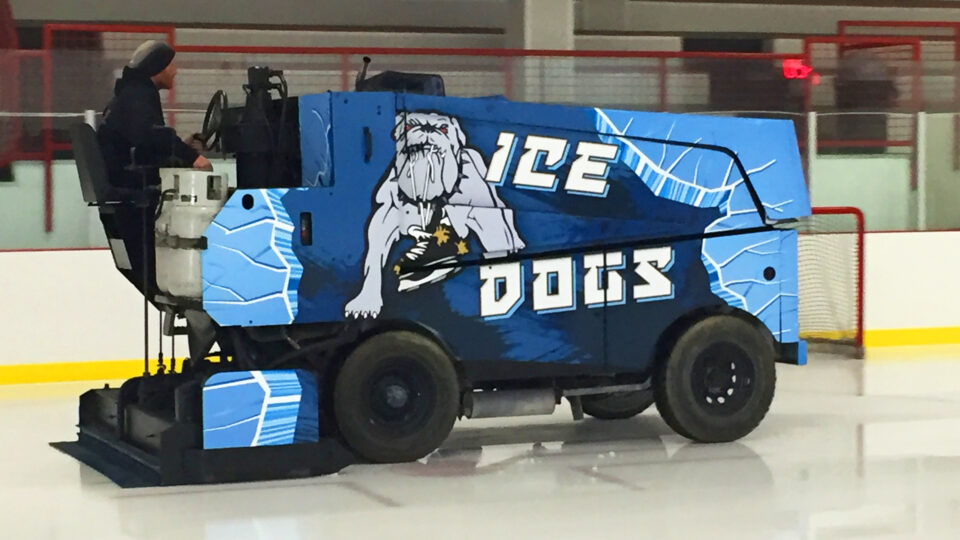 Blue Zamboni vinyl wrap with ICE DOGS text and logo of bulldog with skates in his mouth cleaning the ice
