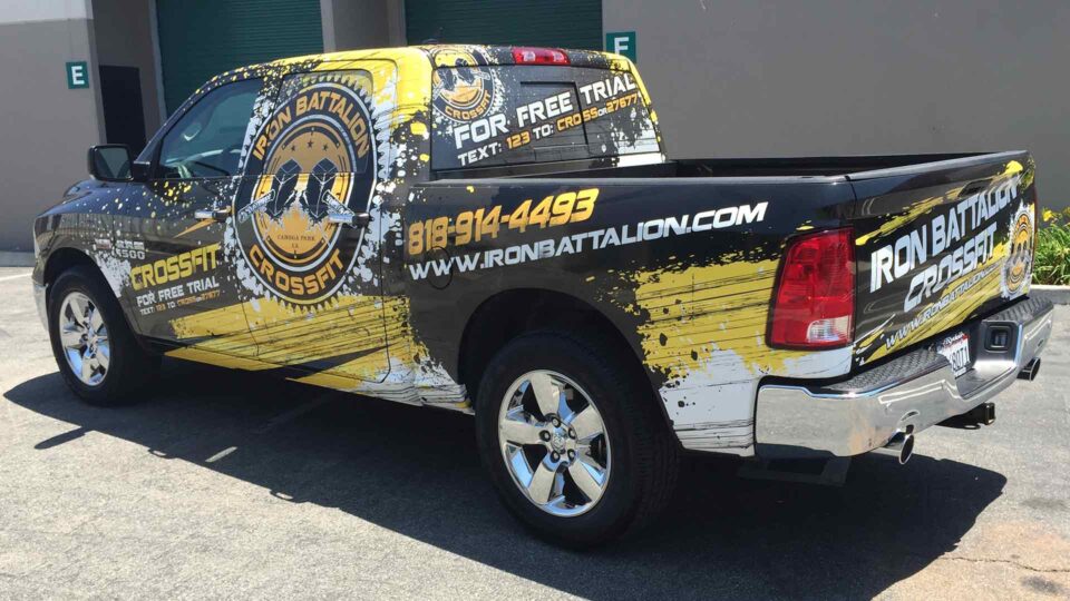 Black Ram Truck with bright yellow paint splatter grahics and Iron Batallion Crossfit logo