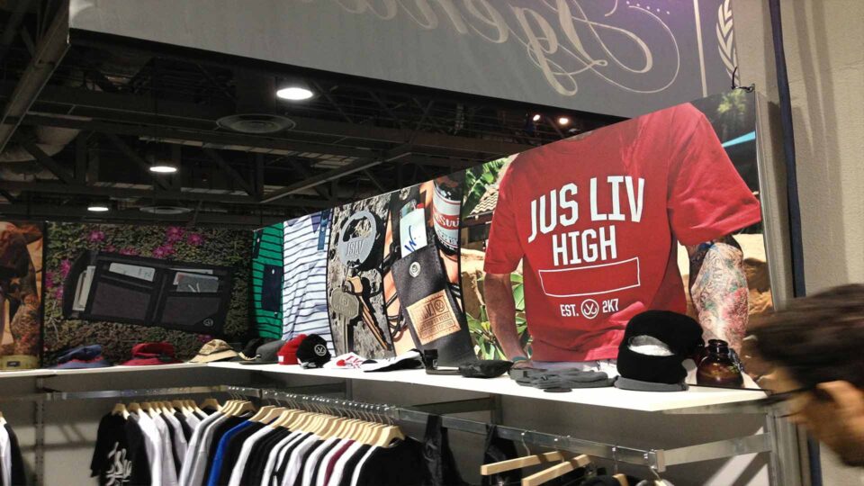 Colorful gator board vinyl printed trade show booth graphics featuring JSLV tshirt, shorts, wallet and accessories.