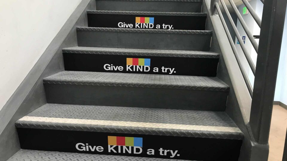 Black vinyl stair graphics with Kind logo and white text