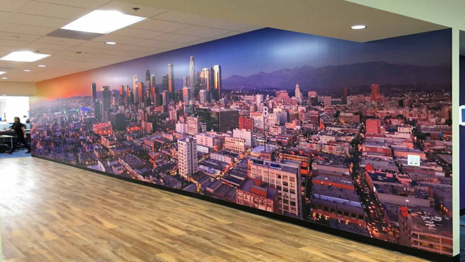 Colorful wall graphic featuring aerial shot of LA skyline