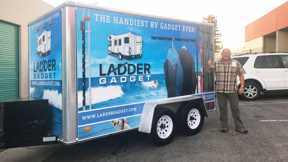 Blue color trailer wrap featuring a surfer and RV for Ladder Gadget