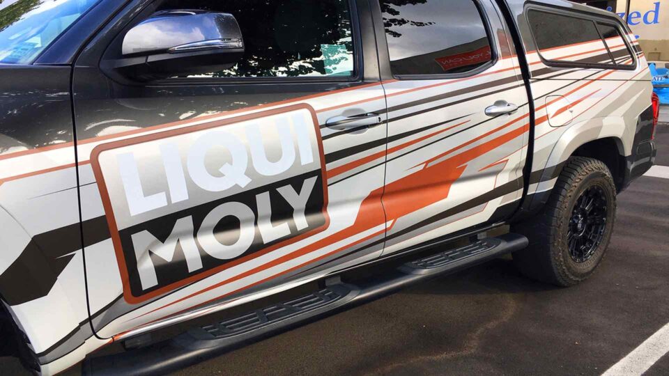 Grey, red and white stripes partial Tacoma Vehicle wrap with Liqui Moly Logo