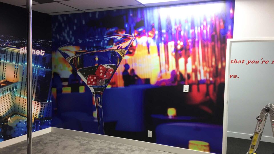 Colorful wall graphic featuring a martini with dice in the glass and muted nightlife background