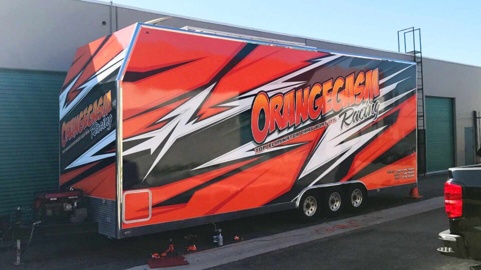 Bright orange black and white trailer wrap with lighting bolts and orangegasm racing logo