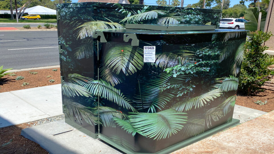 Outdoor electric panel wrap featuring green palm leaves design