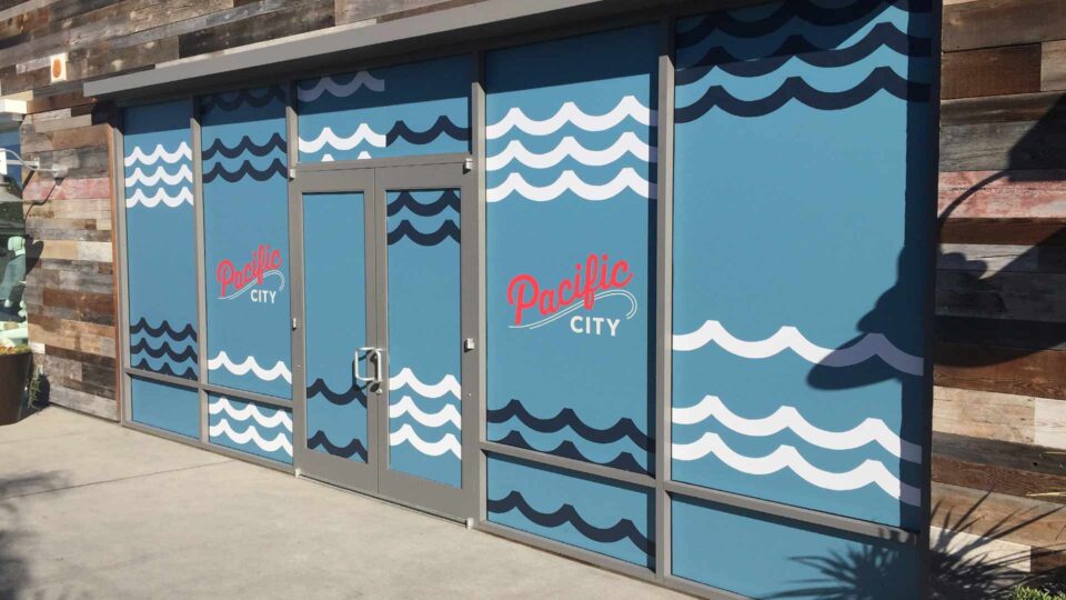 Blue solid window graphics with waves and Pacific City in red