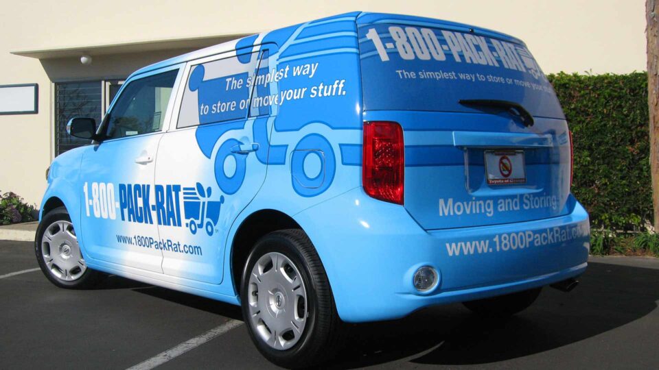 Blue and white scion vehicle wrap with pack rat logo