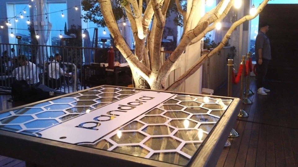 White Pandora die cut decal on glass and wood table in restaurant for special event