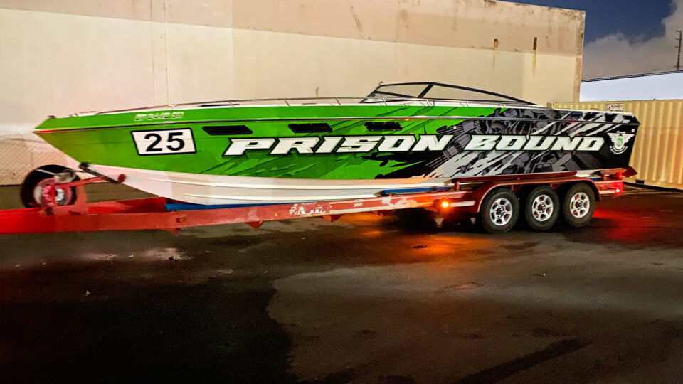 Boat wrap with green and black background and white PRISON BOUND lettering