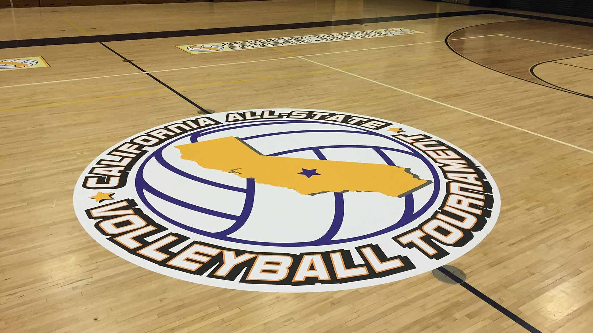 Round gym floor decal with a volleyball and state of California in yellow in the center.