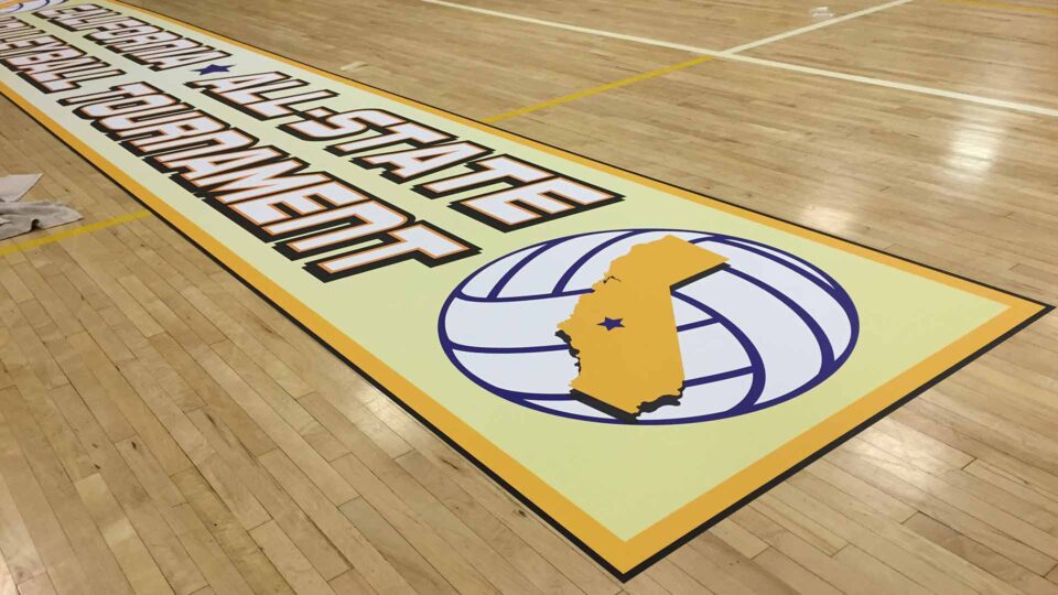 Rectangle volleyball floor vinyl graphic with text in white, yellow and black and a blue and white volleyball with yellow state of california