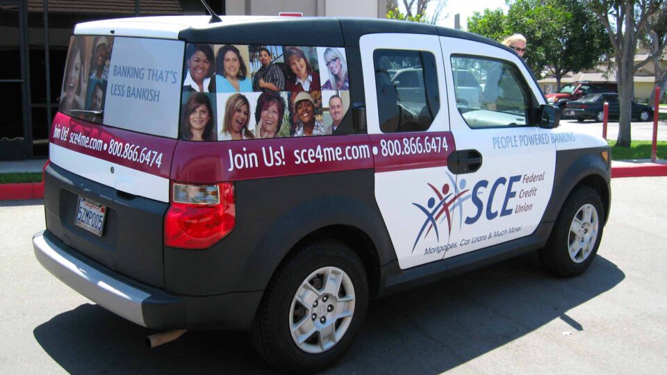 Partial Honda Element wrapped with images of people and SCE credit union logo