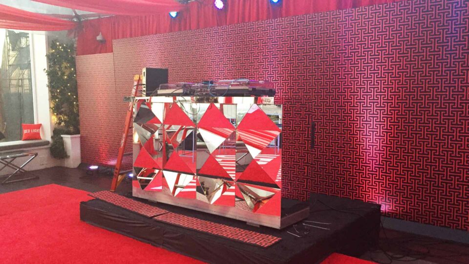 Red gemoetic dj booth wrap with red and black media wall and red carpet for special event