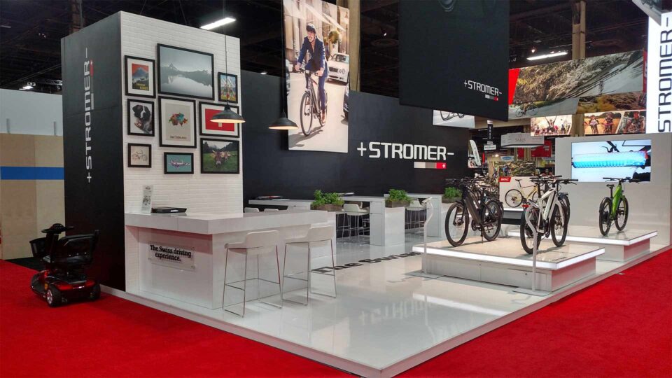 Printed trade show booth walls with Stromer logo and images of ebikes outdoors
