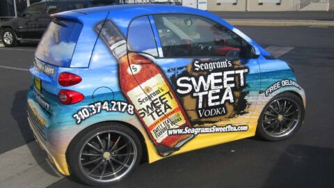 beach background with Sweet Tea bottle graphic wrap on a tiny Smart Car