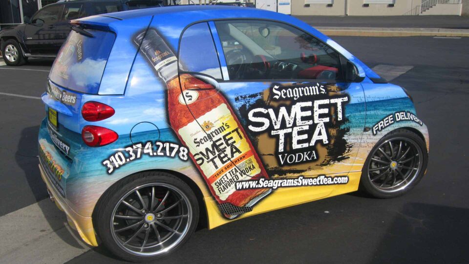 beach background with Sweet Tea bottle graphic wrap on a tiny Smart Car