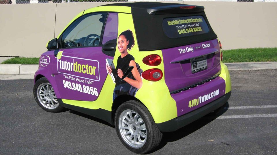 Purple and yellow smart car wrap with student for Tutor Doctor
