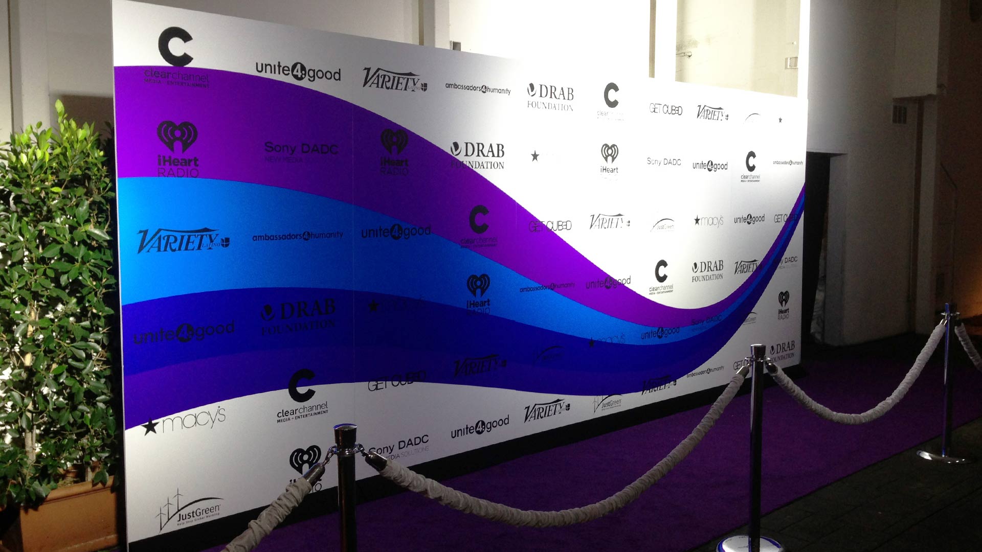 White media wall with blue and purple stripes and black sponsor logos for Variety event